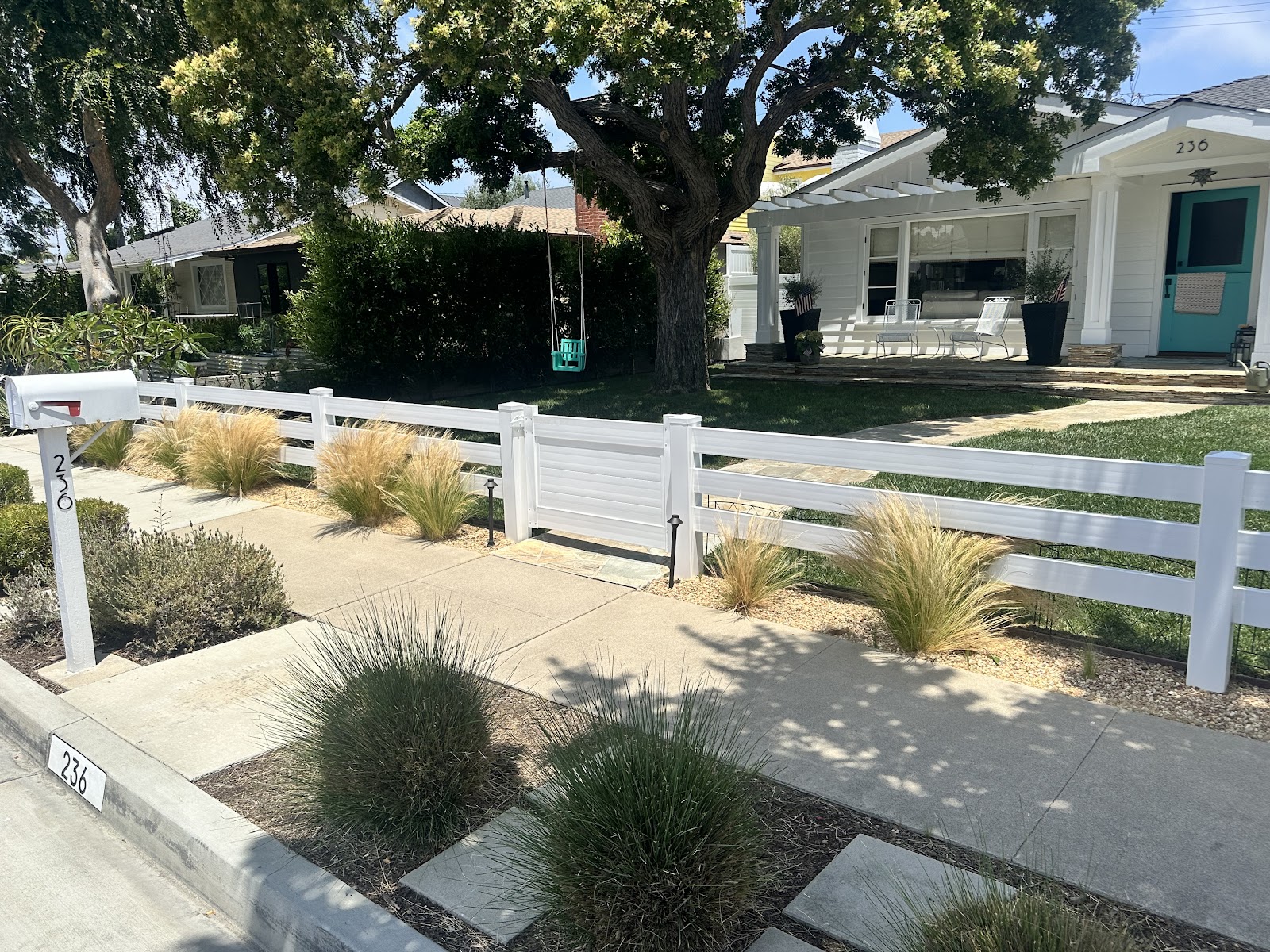 White picket fence with drought-tolerant landscaping