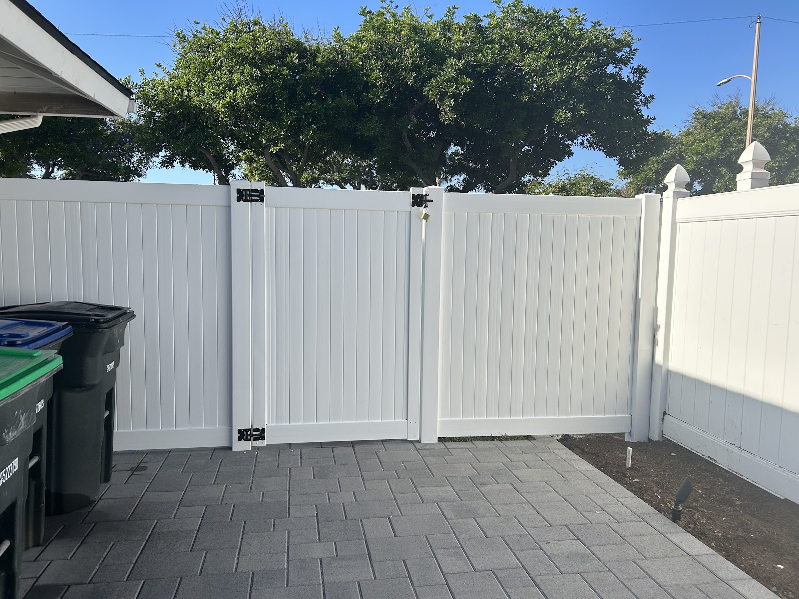 White vinyl privacy fence installed along a backyard